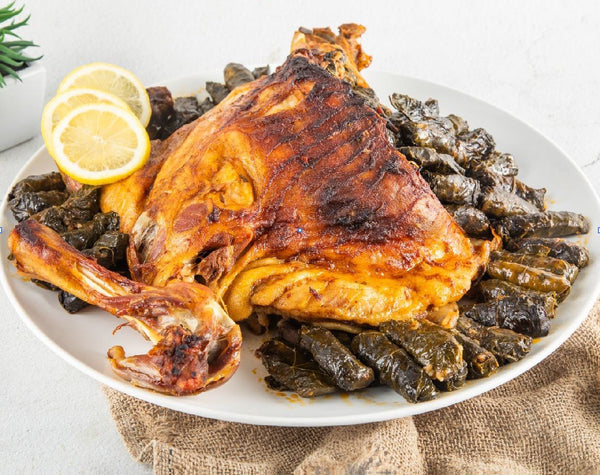 Plated dish of roasted chicken with pickled vegetables and lemon slices, branded with Tazweed Catering Services.