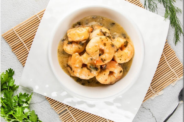 Bowl of shrimp dish on a white plate with Tazweed Catering Services branding.